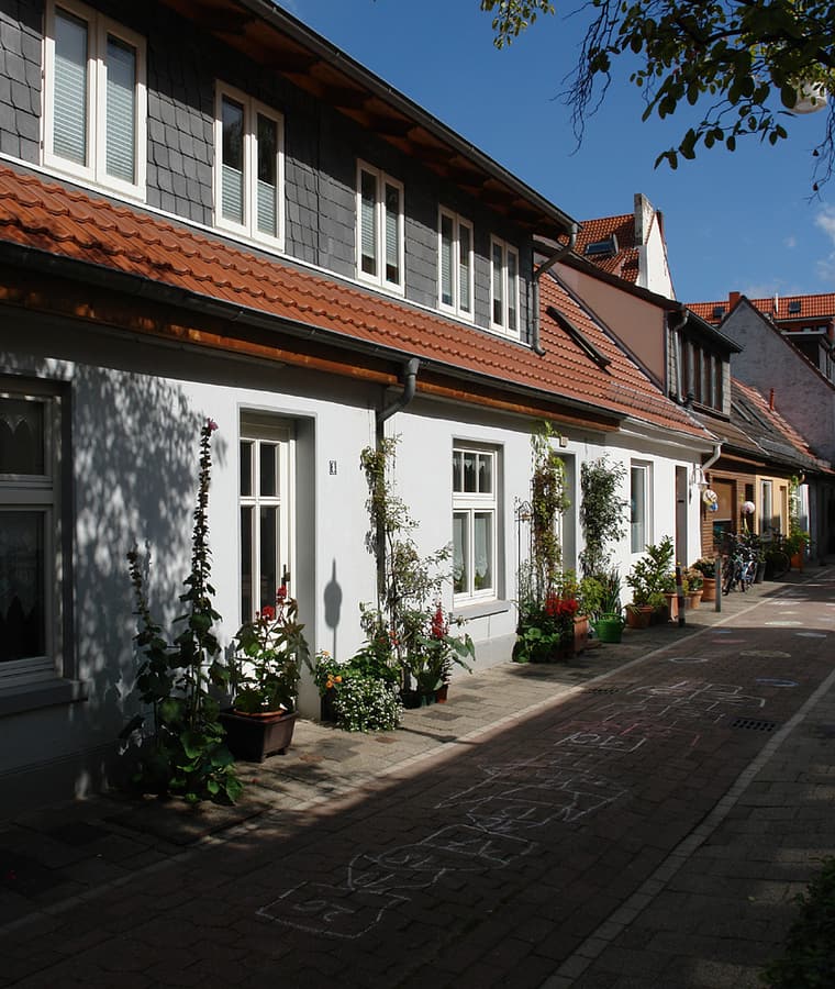 Straßenzeile mit schmalen Bremer Häusern, roten Ziegeldächern und Vorgärten