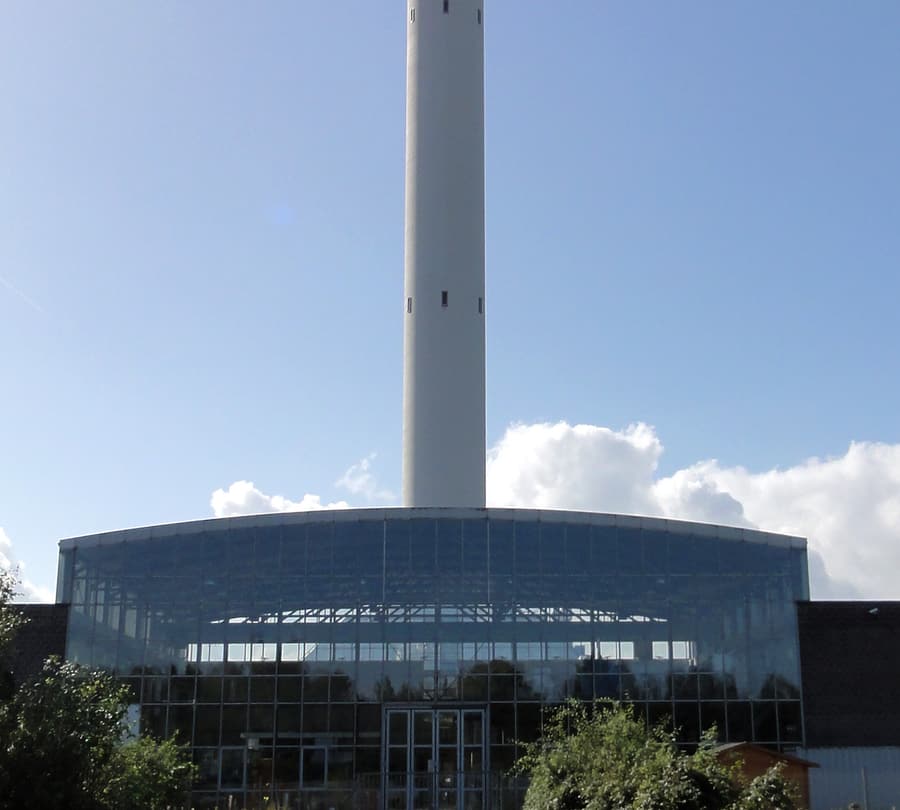 Der weiße Fallturm der Universität Bremen im Technologiepark Horn-Lehe, im Vordergrund die gewölbte Glasfassade des Fallturm-Basisgebäudes