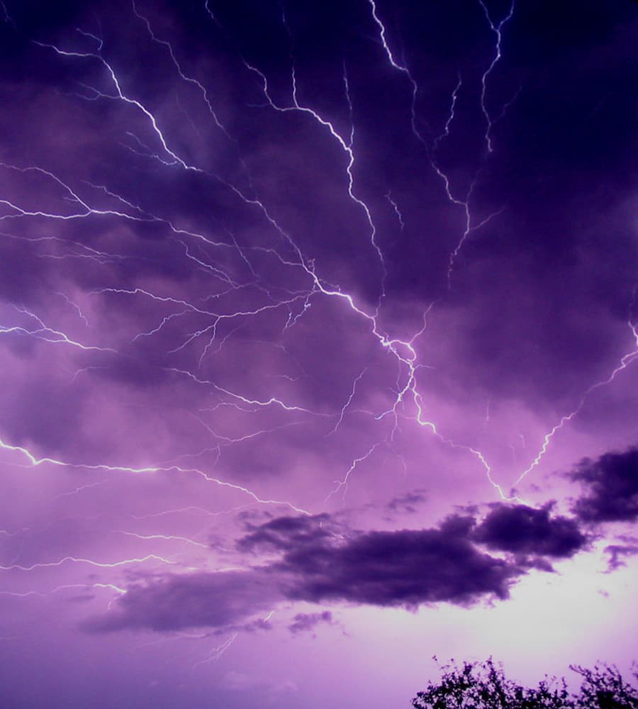 Blitze bei einem Gewitter über offenem Gelände — Auslöser für Überspannungen im Stromnetz